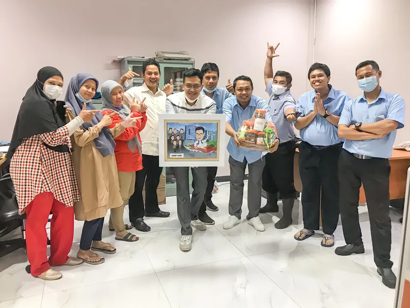 Rekan kerja bermasker mengangkat tangan merayakan penyerahan karikatur kelompok berbingkai.