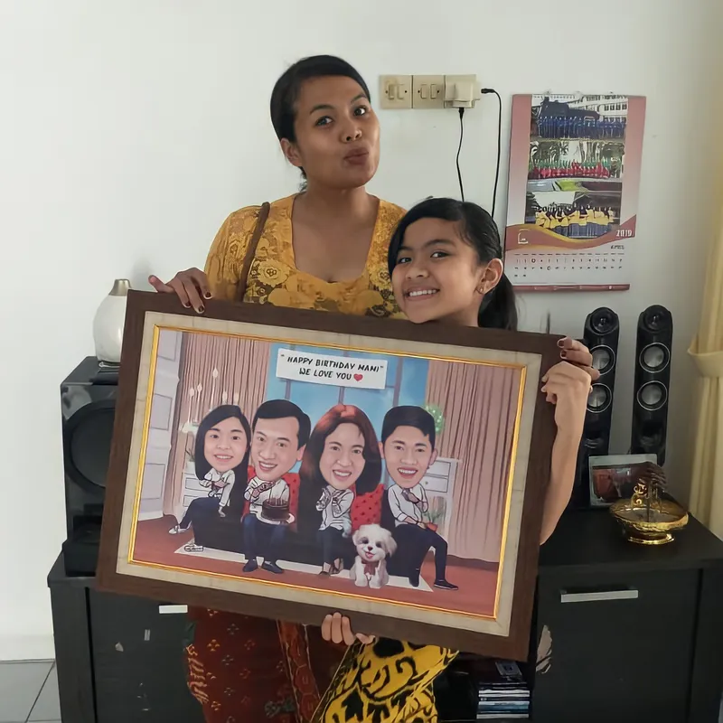 Seorang ibu dan anak perempuannya memegang karikatur keluarga berbingkai di rumah.