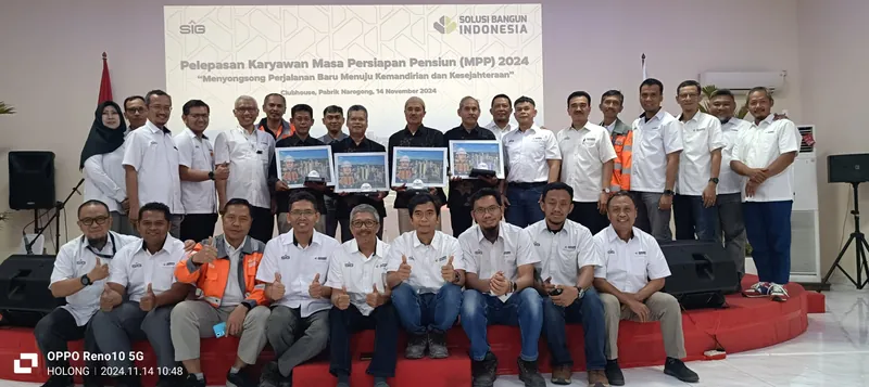 Acara pelepasan karyawan masa persiapan pensiun dengan karikatur berbingkai di depan peserta.