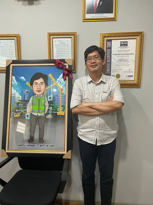 Seorang pria berdiri di samping karikatur berbingkai bertema pekerjaan konstruksi.