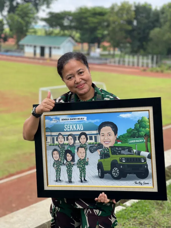 Anggota TNI perempuan memegang karikatur berbingkai bertema kendaraan dinas di lapangan.