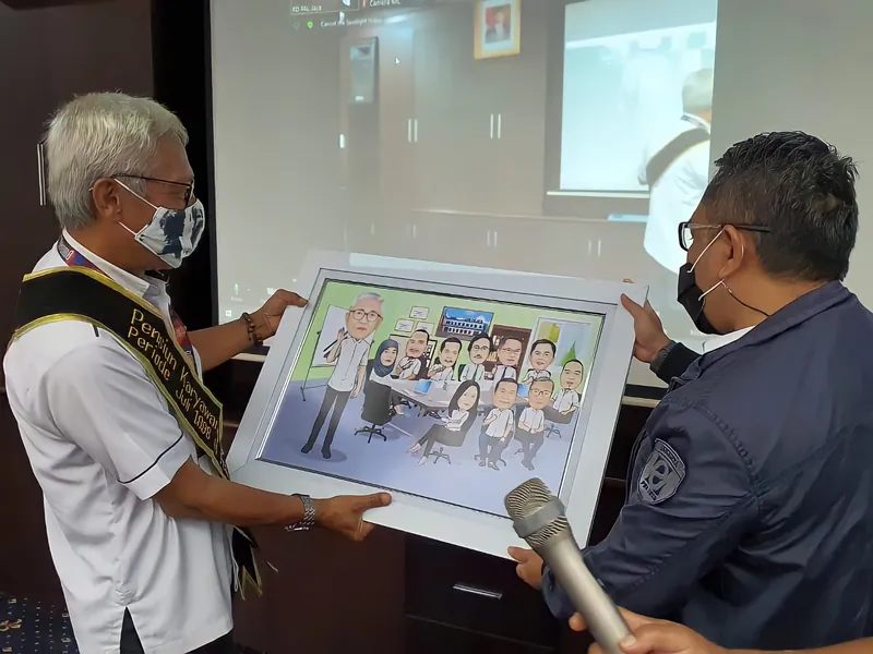 Dua pria memegang karikatur kelompok berbingkai di ruang seminar.