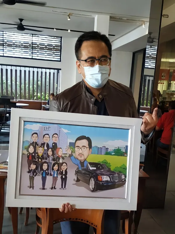 Seorang pria memegang karikatur kelompok berbingkai bertema mobil.