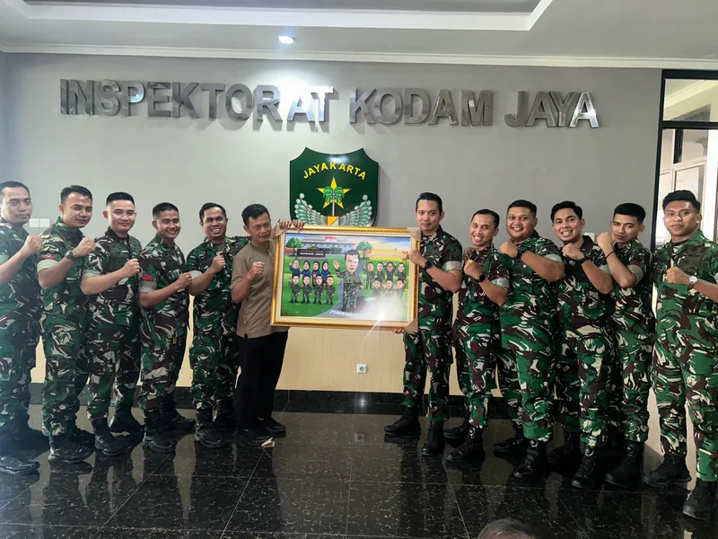 Anggota TNI berbaris di Inspektorat Kodam Jaya memegang karikatur kelompok berbingkai.