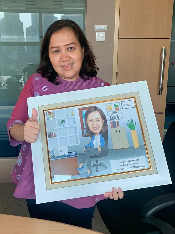 Seorang perempuan mengacungkan jempol sambil memegang karikatur berbingkai.