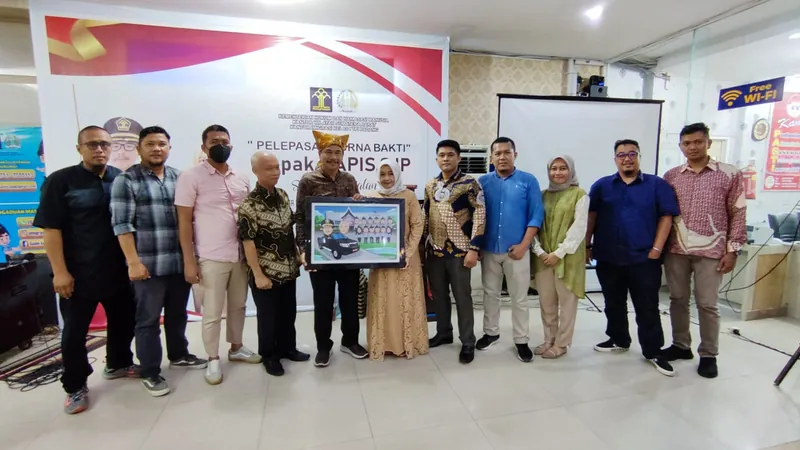 Rekan kerja berbaris memegang karikatur kelompok berbingkai di ruang acara.