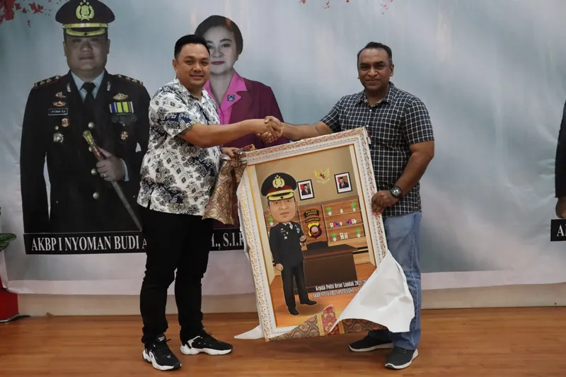 Penyerahan karikatur berbingkai kepada pejabat kepolisian di ruang acara.