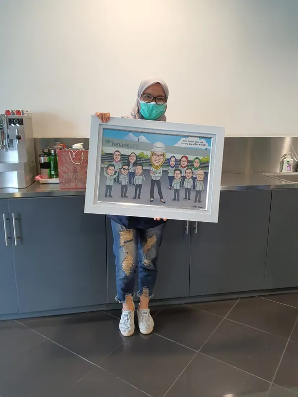 Seorang pria memegang karikatur kelompok berbingkai di ruang kerja.