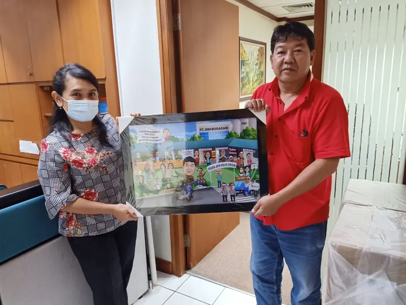 Dua orang memegang karikatur kelompok berbingkai di ruang kantor.