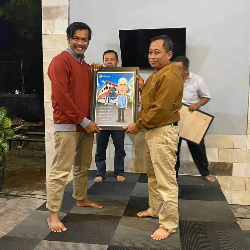 Penyerahan karikatur berbingkai antara dua pria di ruang acara.