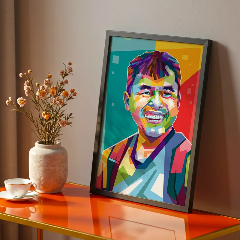 Lukisan WPAP berbingkai hitam menampilkan potret pria tersenyum yang dipecah jadi bidang-bidang warna tegas biru, magenta, dan kuning, bersandar di meja oranye